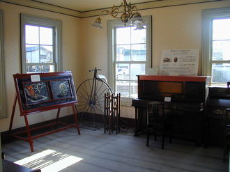 写真：日当たりの良い部屋に明治時代の自転車やオルガンが置かれている