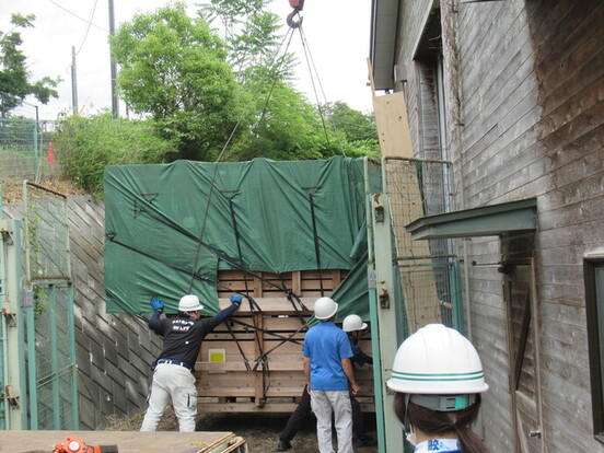 写真:持ち上がった輸送箱が地面に着く直前