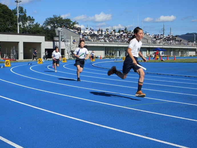 写真：バトンを持って走る女子生徒たち