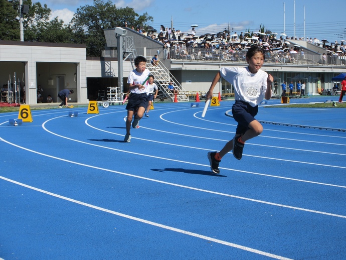 写真：バトンを持って走る男子生徒たち