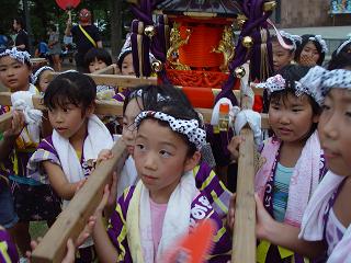写真：はっぴを着て神輿を担ぐ子ども達