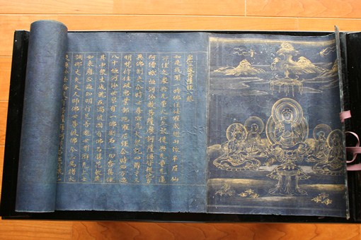写真：紺色の和紙に金泥で絵と文字が書かれている巻物