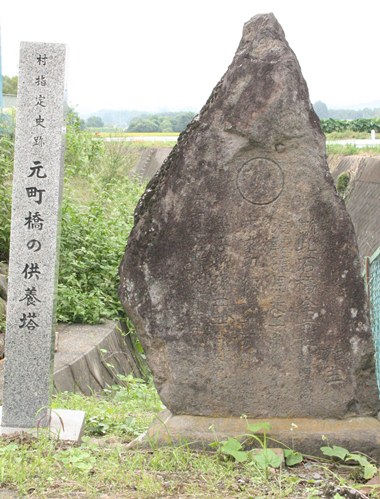 写真：石碑の立っている横に石の杭が立っており、史跡の名前が彫られている