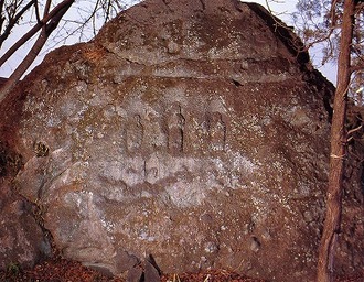 写真：大きな岩に三体の仏像が彫られている