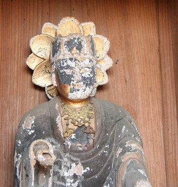 写真：仏像の顔の表面が剥がれ、損傷が激しい様子