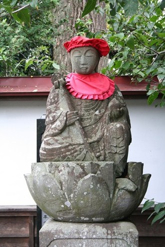 写真：赤い涎掛けと帽子を被った地蔵菩薩坐像