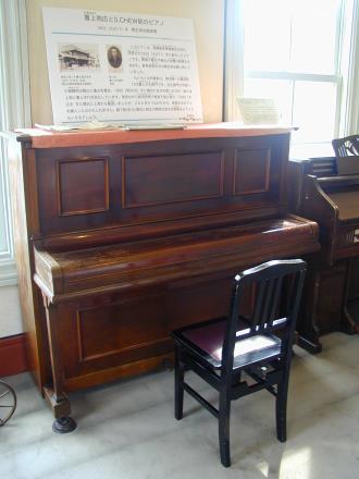 写真：外側が木製で茶色の塗料の塗られたピアノ