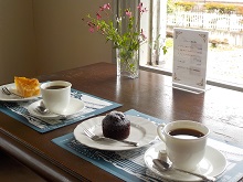 写真：コーヒーとケーキがそれぞれお皿に乗せられてる