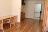 写真：二人部屋のリビングに木製の机と椅子が置いてある様子