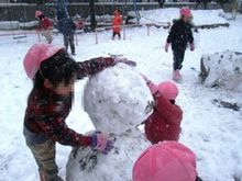 写真：雪だるまと園児