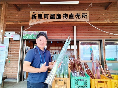 （写真）宮本隊員がねぎを持っている様子