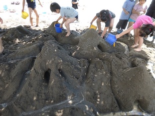 砂場で山作りの写真