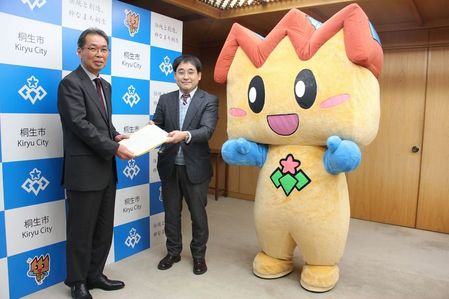 写真：戦略会議小竹委員長から亀山市長に報告書を手渡す様子