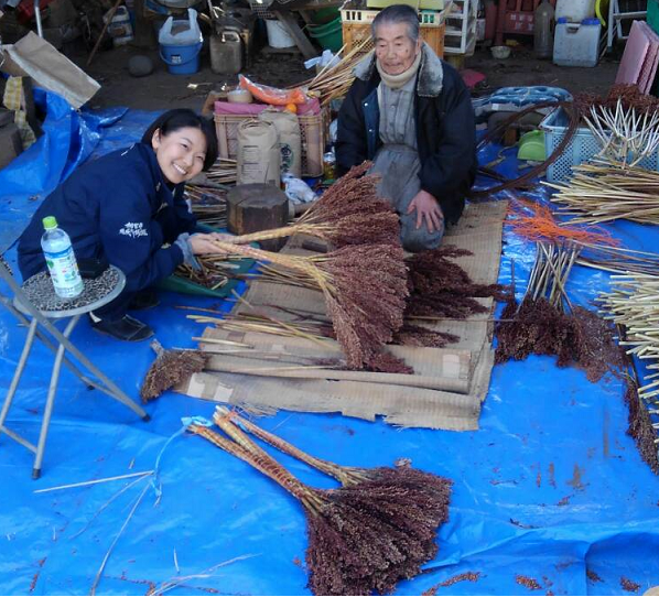 箒づくりの作業を見学中の北條隊員の画像