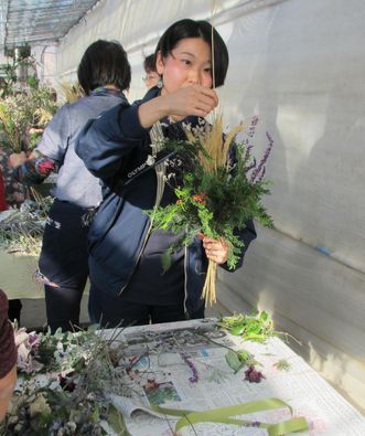 花束のバランスをみながら残りの植物を追加している写真