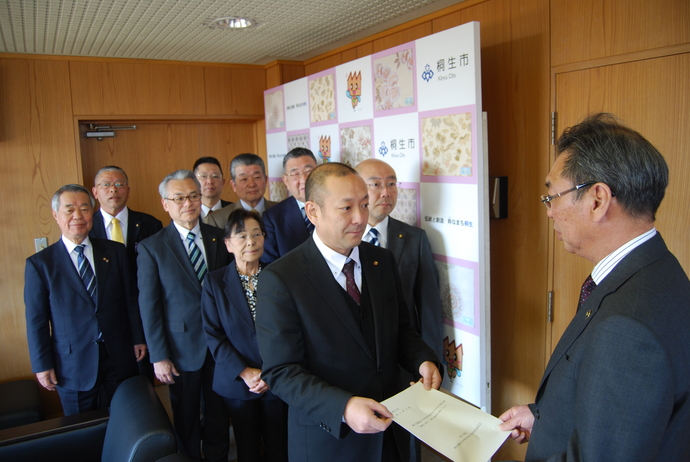 写真:委員会から市長に提言書を手渡す様子