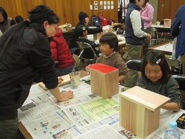 写真:親子で作った巣箱に色をぬる子ども