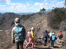 写真:山の稜線を歩く親子