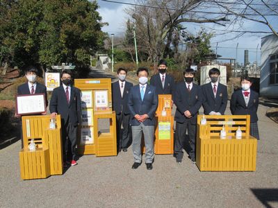 写真：桐生工業高等学校による消毒用ボトルスタンド、パンフレットスタンド引き渡し式の様子