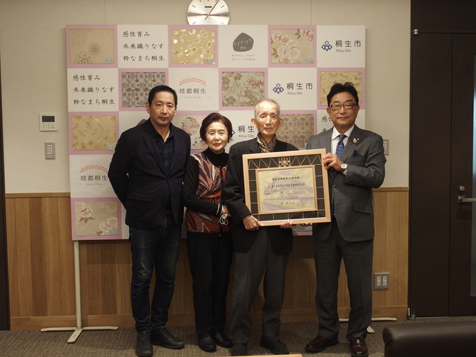 市長と並び指定標識を持つ写真