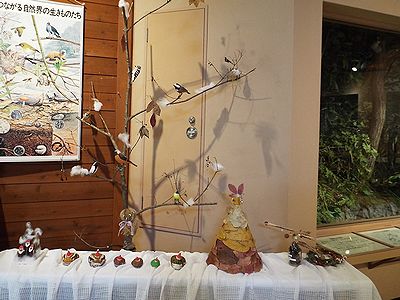 写真:木彫りの鳥や石に色塗りをしたカエルの展示