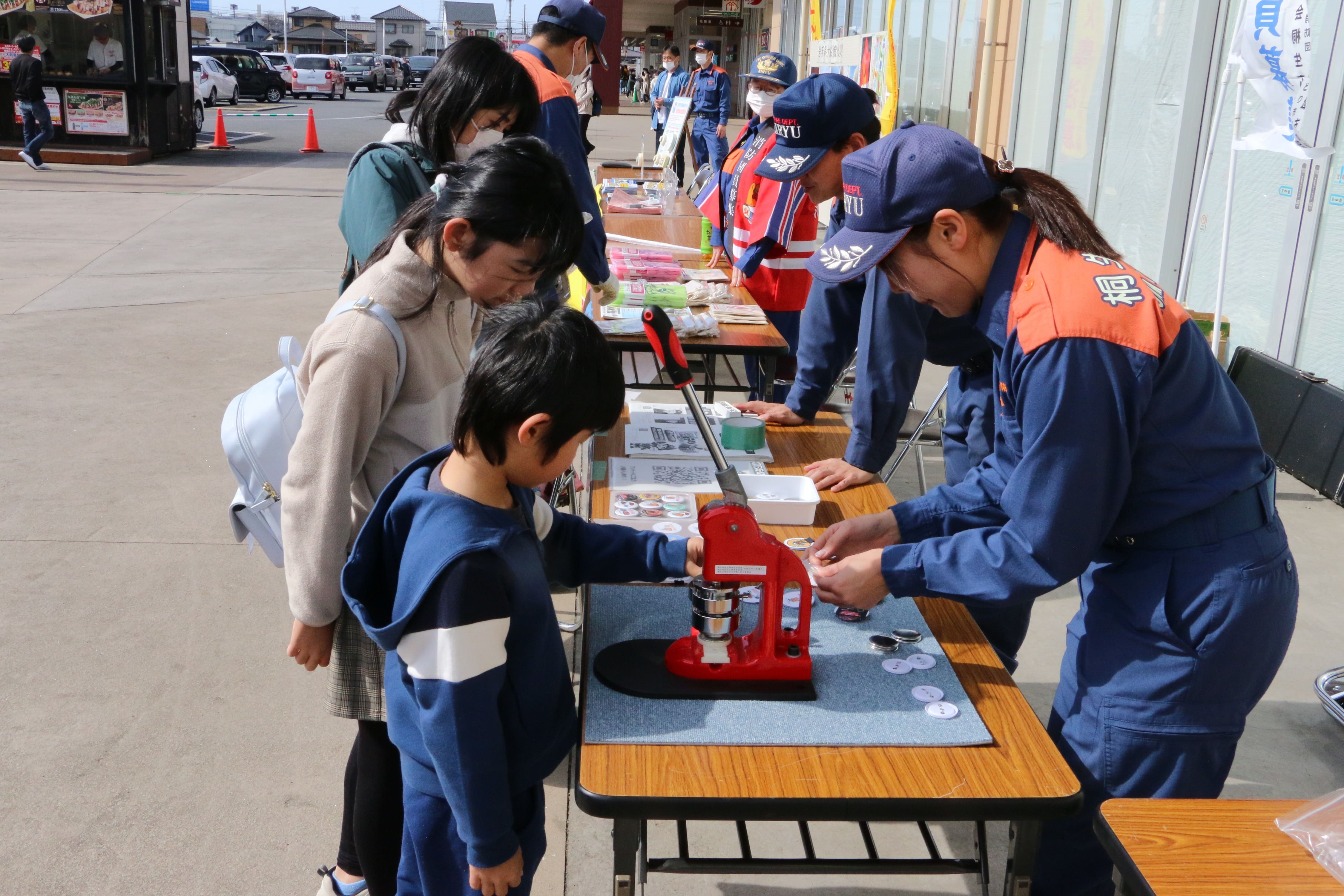 写真：缶バッジ作成体験をする親子の様子