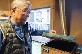 燻製の設備を見る鈴木さんの写真
