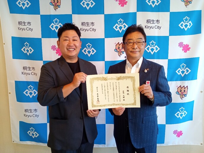 岩崎隊員と市長が二人で感謝状を掲げている写真