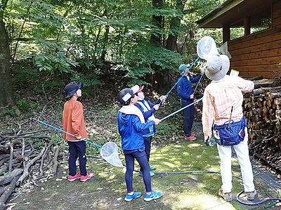 写真:レンジャーと網をもって虫をさがす子供たち