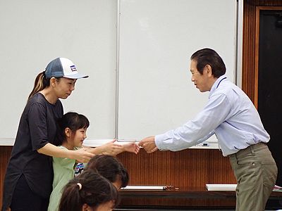 写真:職員から終了証を受け取る親子