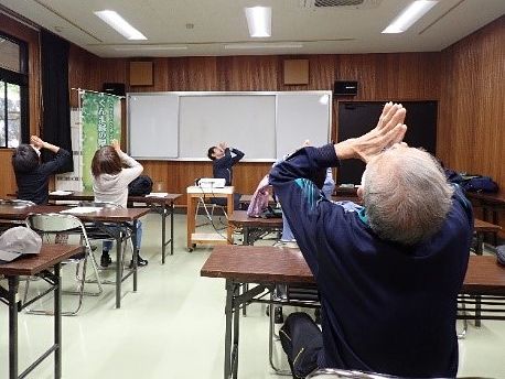 写真:椅子に座りながらできるストレッチを教わる参加者