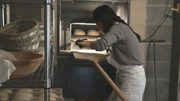 写真：パンを石窯に入れる様子
