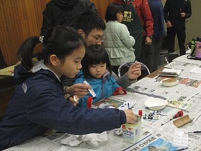 写真：鳥の写真を見ながら絵の具を選ぶ親子