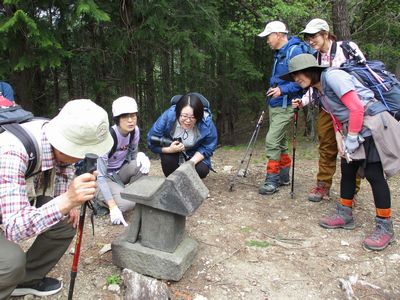 写真:石碑を囲み、説明を聞く参加者たち