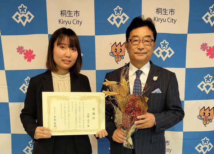 写真：感謝状を掲げる河野隊員（左）とプレゼントされたブーケを持つ市長（右）
