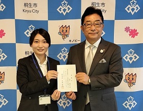 写真：委嘱状を市長（右）と共に持つ細谷隊員（左）