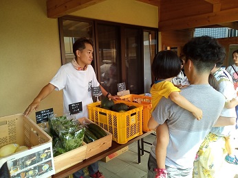 写真：くろほねマルシェで黒保根の野菜を販売する大畠隊員
