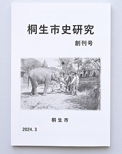 『桐生市史研究』創刊号の表紙。桐生が岡動物園に象のイズミが初めて来た日飼育員から餌をもらう様子の写真。