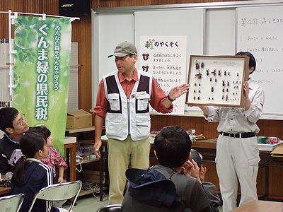 写真:昆虫の標本をみながら説明を聞く参加者たち