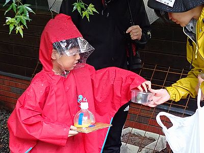 写真:かっぱを着て虫取りをする子供
