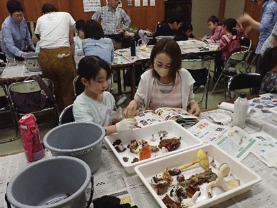 写真:図鑑とキノコを見比べるお母さんと娘さん