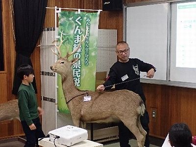 写真:オス鹿などのはく製を間近で見ながら話を聞く参加者
