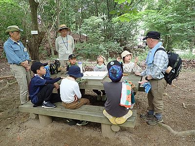 写真:木の葉や実を見つけるゲームの説明を聞く子どもたち