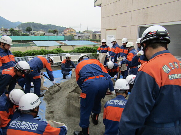 写真：土をシャベルですくう消防職員