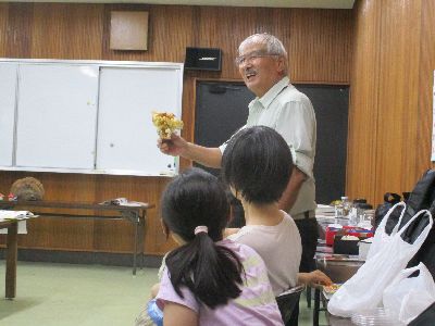 写真：キノコを手に持ち、参加者に解説する講師