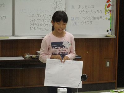 写真:A3版のフィールドノートを持ち、部屋の前に立つ子供