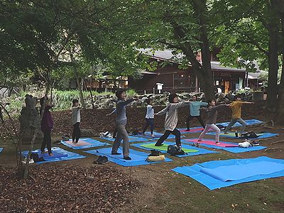 写真：広場に敷いたシートの上でポーズをとる参加者たち