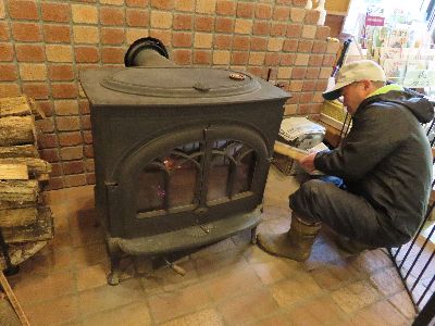 写真:薪ストーブに、薪を入れる職員