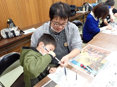 写真:色塗り作業を一緒にする親子