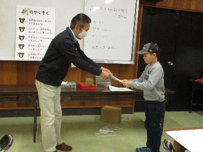 写真:所長から子どもに証書を渡す
